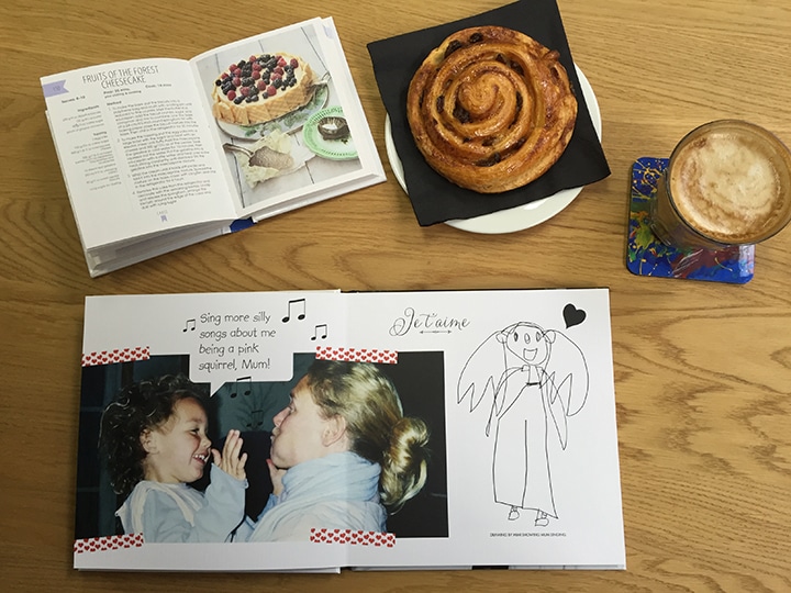 Photo book, recipe book, pastry and coffee on a table