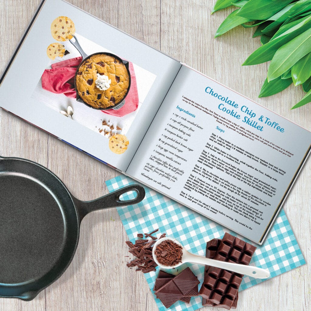 Recipe book, frying pan and chocolate on a table