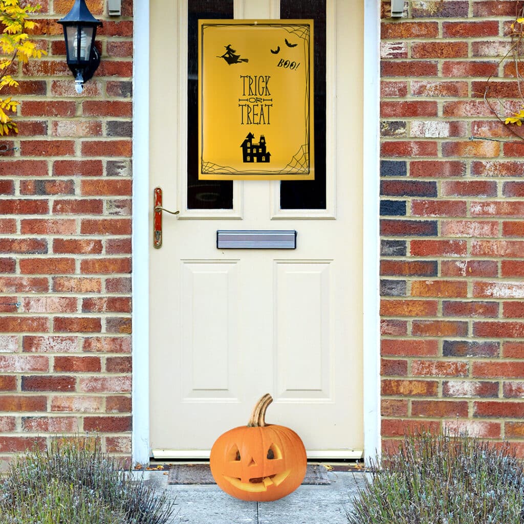 Halloween poster on a front door with a pumpkin on the door step