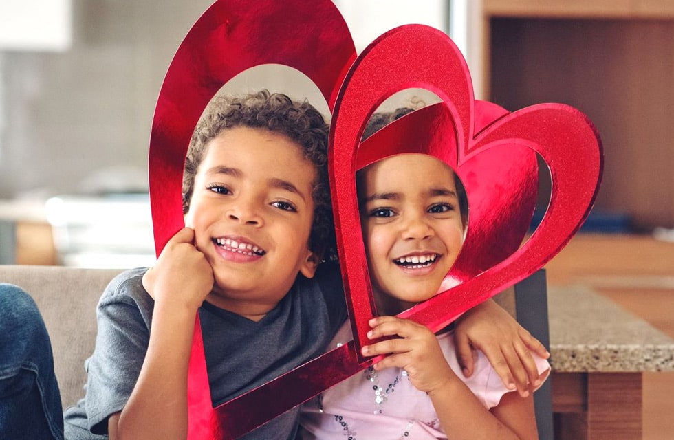 Two small children playing with Heart shaped props