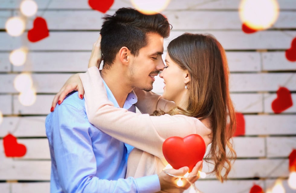 A couple embracing with heart decor in the background